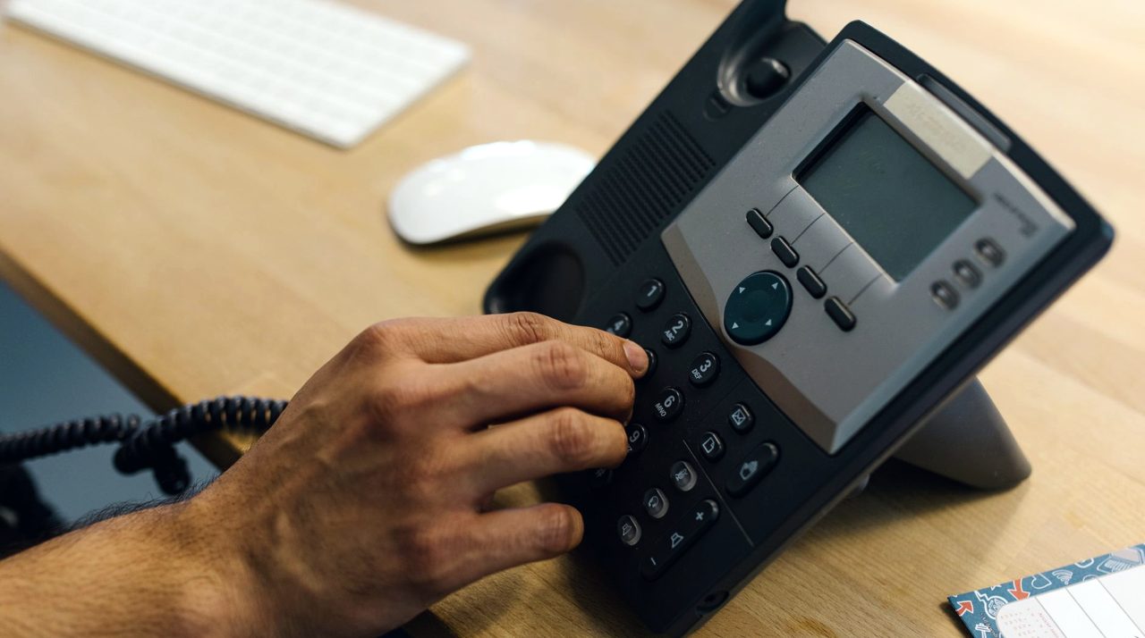 Main sur un téléphone de bureau