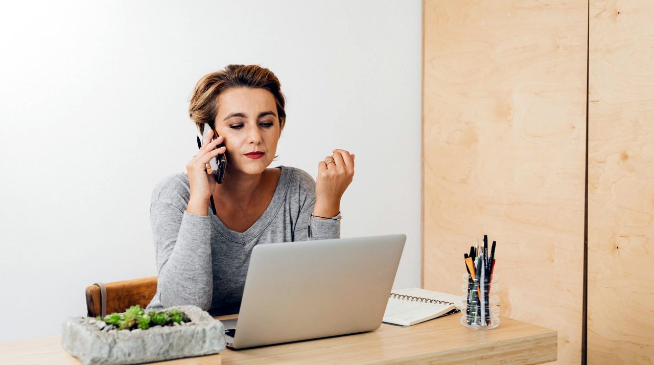 Collaboratrice au téléphone devant son ordinateur
